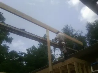 Carpenter setting a ridge beam over a new addition frame — Ice Dam Removal by Roofing Brothers in Palisades
